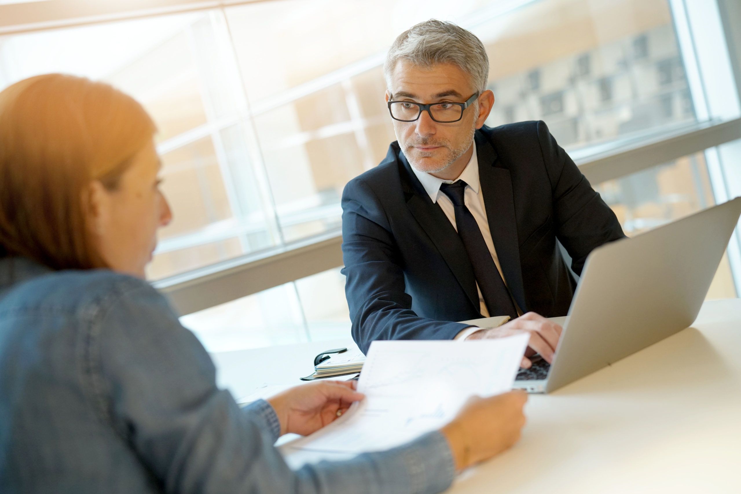 Woman in banker's office signing financial loan for project